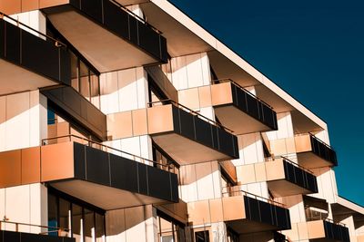 Low angle view of modern building against clear blue sky