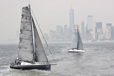 Sailboats sailing in sea against sky