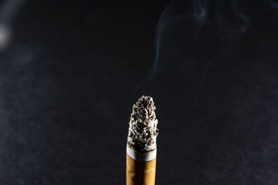 Close-up of cigarette against black background
