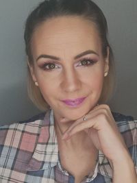 Portrait of smiling woman against gray background