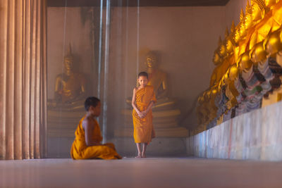 Side view of boy praying in buddhist temple