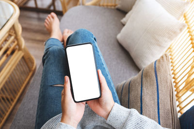 Low section of woman using mobile phone