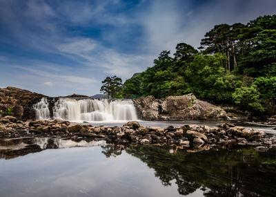 Scenic view of waterfall against sky