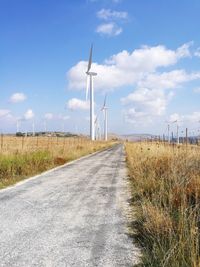 Road by field against sky