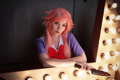 Portrait of young woman sitting on table