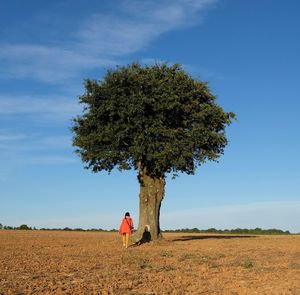 Rear view of person on field against sky