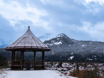 Built structure on snowcapped mountain against sky