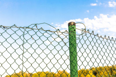 Low angle view of fence against blue sky