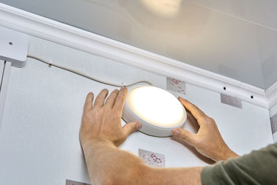 Cropped hand of man holding coffee at home