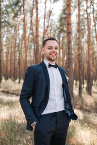 Portrait of young man standing in forest