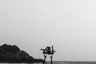 Man photographing sea against clear sky