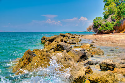 Rock formation on beach against sky