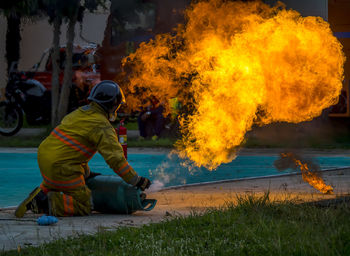 Firefighter extinguishing fire on road