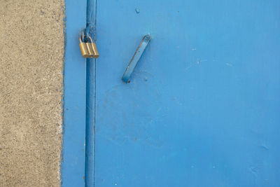 Close-up of metallic structure against blue wall