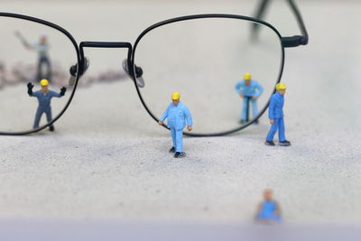 Close-up of figurines and eyeglasses on table