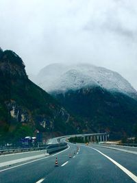 Road by mountain against sky