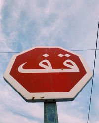 Low angle view of road sign against sky