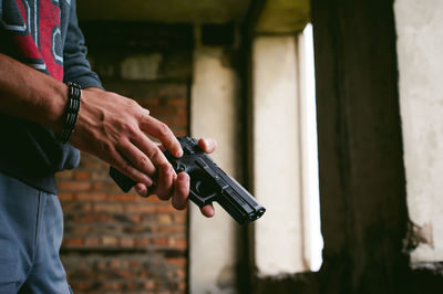 Midsection of man standing against wall