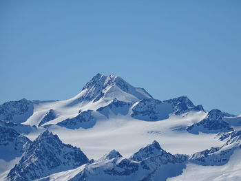 Scenic view of snowcapped mountains against clear blue sky