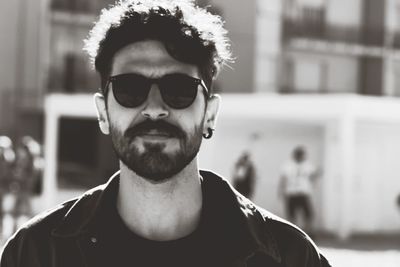 Portrait of young man wearing sunglasses while standing in city