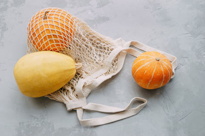 Mesh shopping bag with vegetables. autumn pumpkin harvest