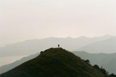 Man standing on mountain against clear sky