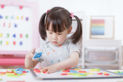 Cute girl playing with toy at home