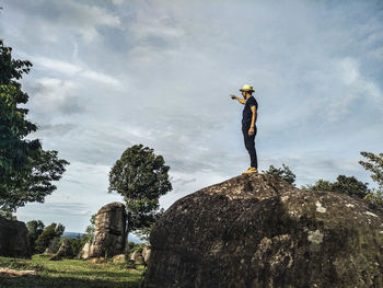 Low angle view of person standing on rock