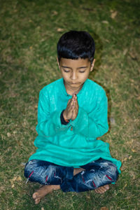Young kid meditating in traditional dress at evening from different angles