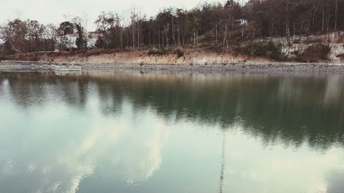 Scenic view of lake in forest against sky