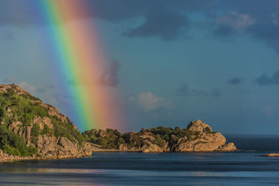 Scenic view of rainbow over sea against sky