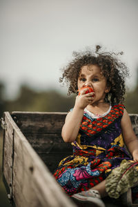 Portrait of cute girl sitting outdoors