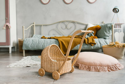 A toy wicker stroller in the children's room