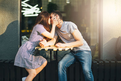 Young couple kissing at outdoor cafe in city