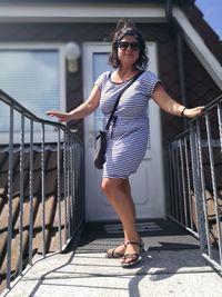 Young woman standing by railing