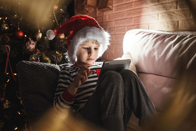 Man using mobile phone while sitting on sofa at home