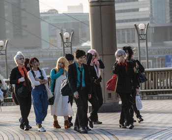 Rear view of people walking in front of building