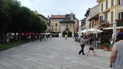 People on street in city against sky