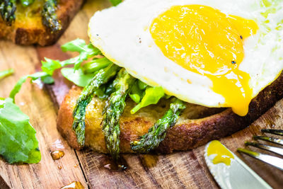 Close-up of fried egg and herbs on bread at table