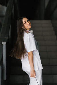 Young woman standing against wall