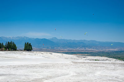 Scenic view of land and mountains against blue sky