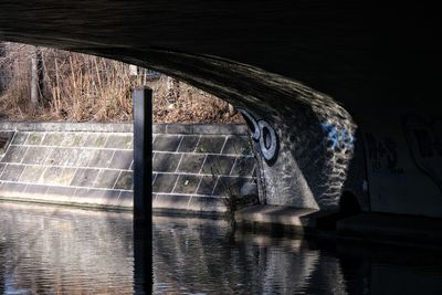 Arch bridge on river against wall