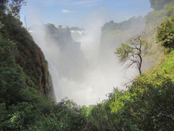 Scenic view of waterfall against sky