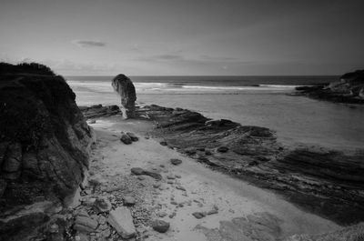 Scenic view of rocks on beach against sky