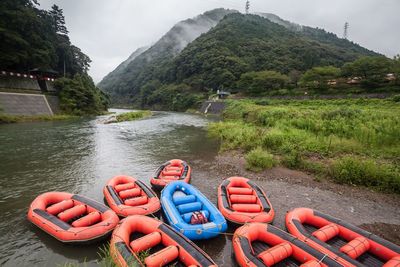 Scenic view of river by mountains against sky