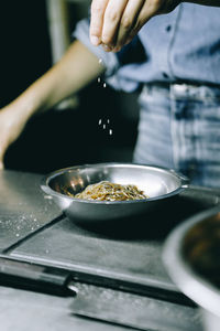 Midsection of person preparing food in kitchen