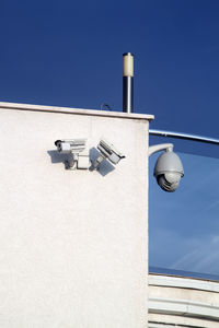 Low angle view of electric lamp against building