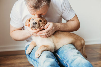 Young man hugging his labrador retriever puppy. the concept of friendship between a dog and a person