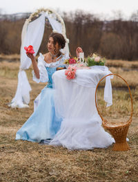 Woman with flower sitting at table outdoors