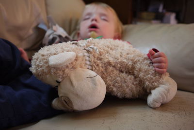 Close-up of boy sleeping with stuffed toy at home